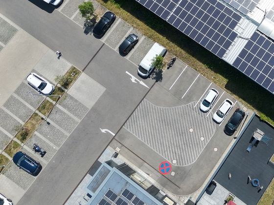 Parkplatz mit markierten Stellflächen und Autos, senkrecht von oben aufgenommen