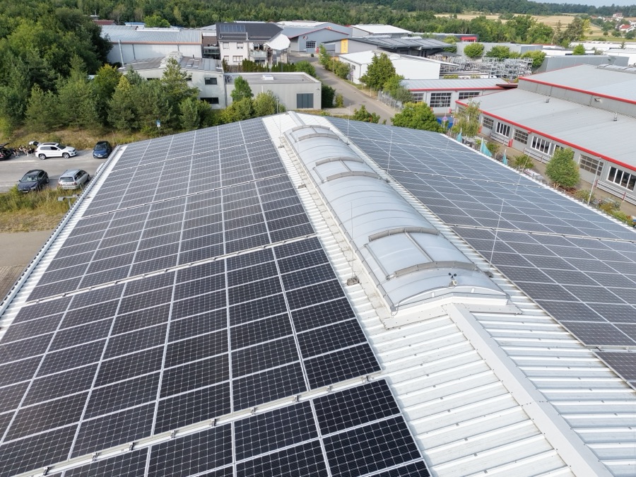 Photovoltaikanlage auf einem großen Hallendach im Gewerbegebiet, von oben aufgenommen