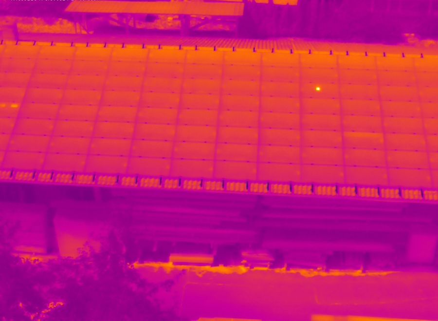 Wärmebild einer Photovoltaikanlage: Module in Magenta- und Orangetönen, ein heller Punkt markiert eine Auffälligkeit